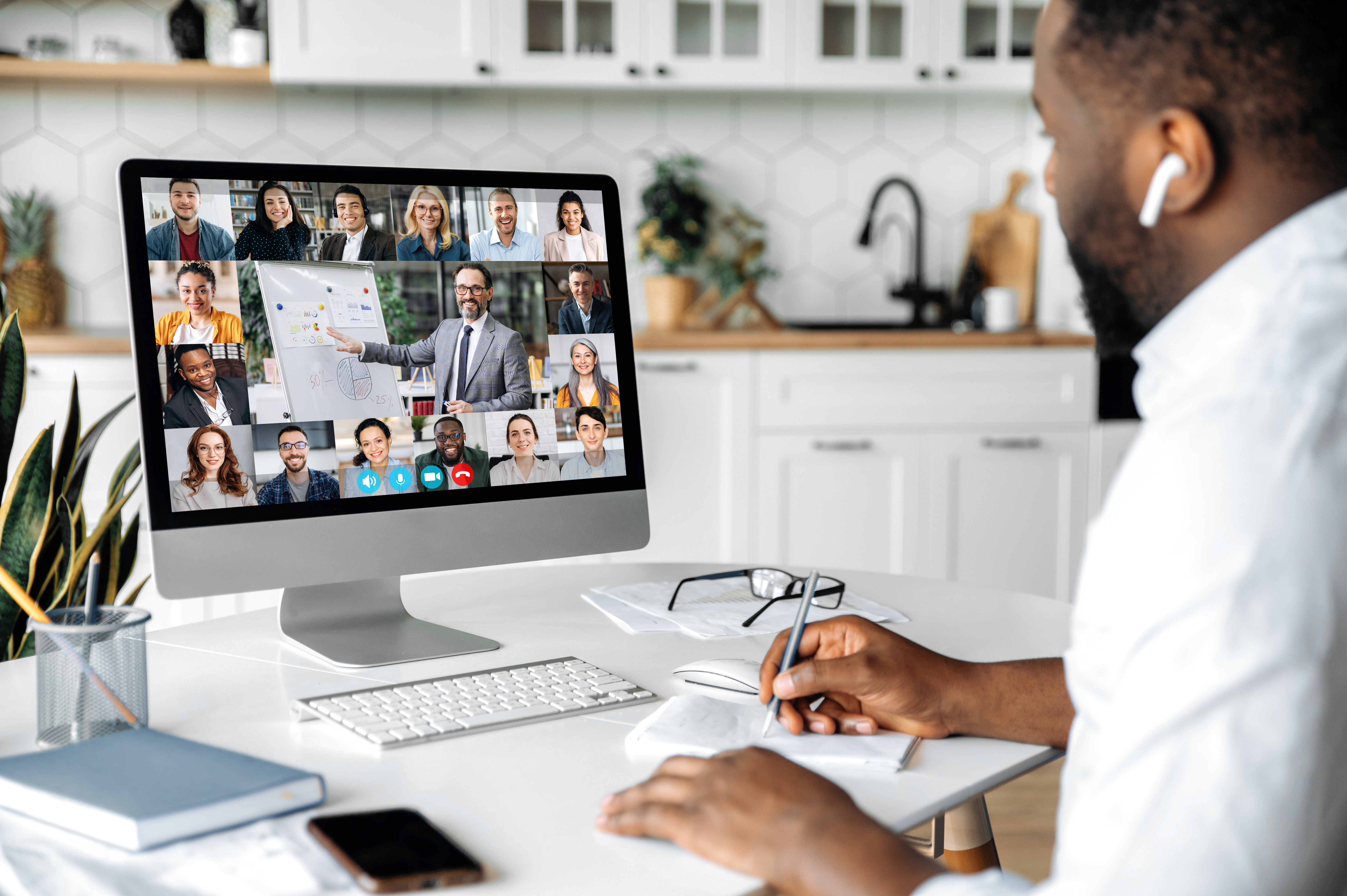 Online education, business seminar. African American smart confident man sit at home at work desk, uses computer, listening to an online financial lecture, taking notes, diverse people on the screen Best Tech Companies to Work for